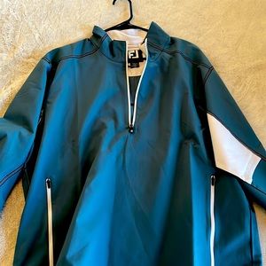 Men’s golf sport half-zip windbreaker with shell fabric and zip hand pockets.